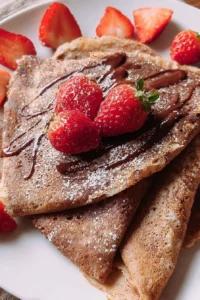 Delicious chocolate crepes served with whipped cream and fresh berries