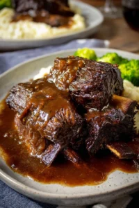 Crockpot beef short ribs in rich gravy served on a plate