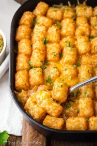 Delicious Tater Tot Casserole served in a baking dish, topped with melted cheese.
