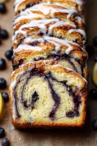 Lemon Blueberry Babka with drizzled icing on a rustic wooden table.