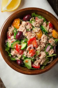 Mediterranean tuna salad with olives, tomatoes, and cucumbers in a bowl