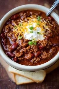 Bowl of classic chili garnished with sour cream and green onions