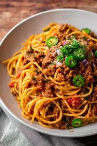 Taco spaghetti dish served in a bowl, garnished with cheese and cilantro.