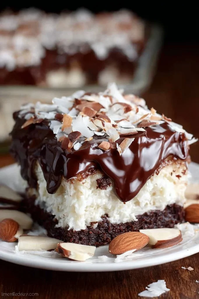 Delicious Almond Joy Poke Cake topped with chocolate and coconut flakes
