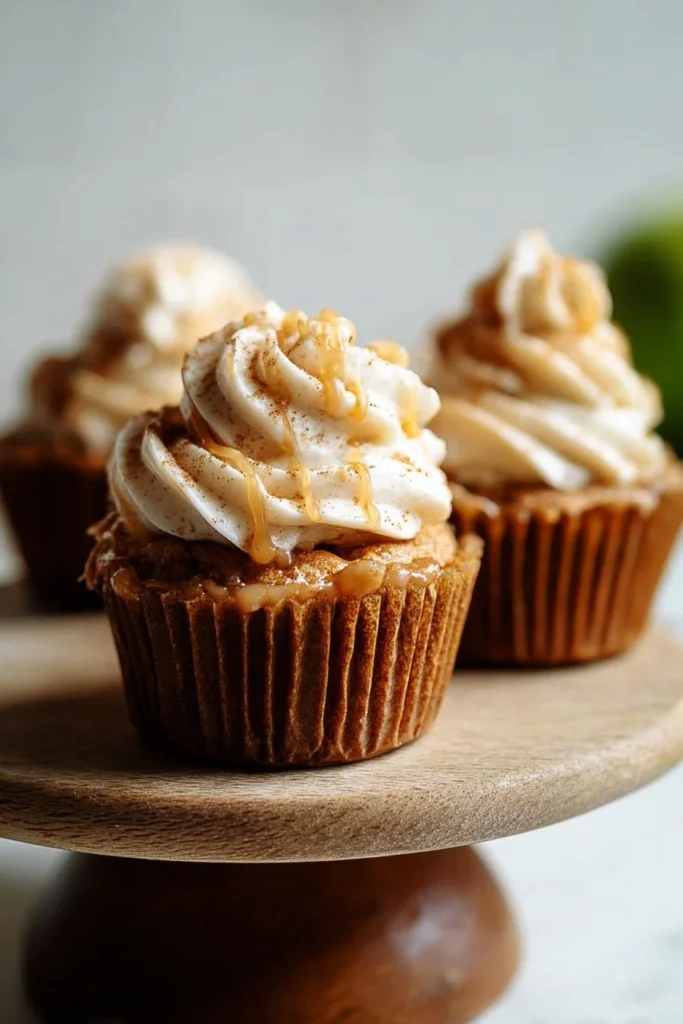 Delicious apple pie cupcakes topped with cinnamon and apple pieces.