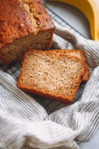 Loaf of freshly baked Banana Beer Bread on a wooden cutting board