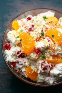 Delicious Ambrosia Salad with fruits and fluffy topping in a serving bowl