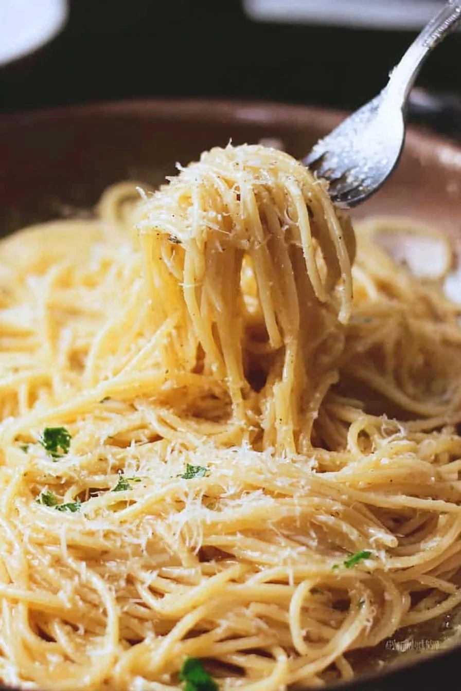 A plate of browned butter spaghetti topped with Mazithra cheese.