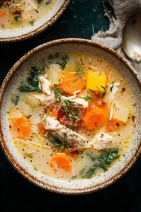 Bowl of delicious Crack Chicken Soup garnished with herbs and shredded chicken.