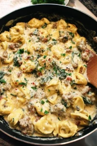 Creamy sausage tortellini skillet served in a pan with garnish