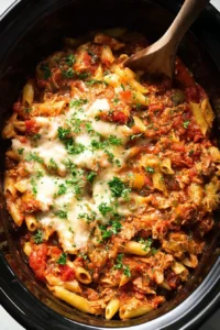 A bowl of Crockpot Million Dollar Pasta garnished with fresh herbs