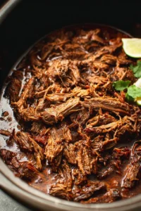 Slow cooker barbacoa beef with spices and herbs served in a bowl