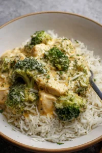 Slow cooker creamy chicken and broccoli dish served over rice