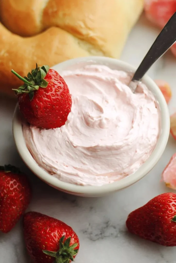 Delicious Strawberry Cream Cheese spread on a bagel with fresh strawberries.