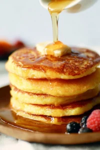 Delicious cornbread pancakes served with honey butter syrup for breakfast