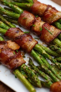 Platter of Bacon Wrapped Asparagus drizzled with balsamic glaze on a wooden table