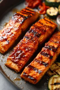 Delicious BBQ Salmon on the grill, garnished with herbs.