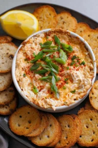 Delicious Cajun Crab Dip served with crackers and garnished with herbs