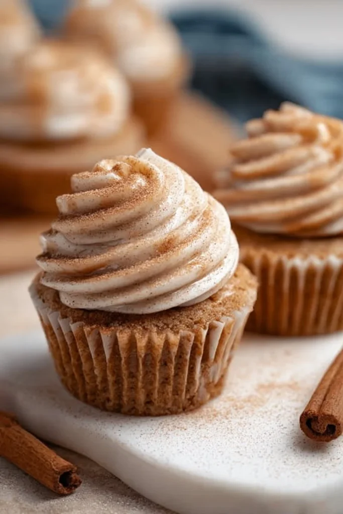 Delicious Churro Cupcakes topped with cinnamon sugar and creamy frosting