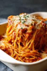 Delicious classic baked spaghetti topped with cheese and herbs