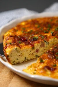 Delicious crustless quiche with vegetables and cheese served on a plate.