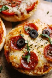 Homemade English muffin pizzas topped with sauce and cheese