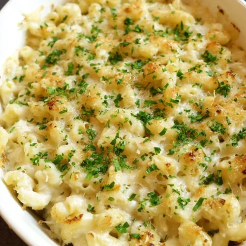 Bowl of cheesy Garlic Parmesan Mac and Cheese topped with herbs and spices.