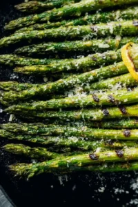 Grilled asparagus with Parmesan cheese and garlic seasoning on a plate.