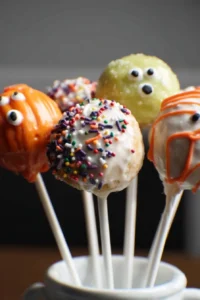 Colorful Halloween donut hole pops decorated with spooky sprinkles