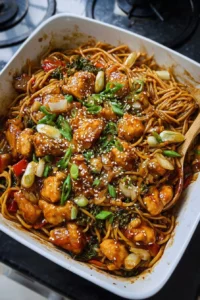Honey sesame chicken noodle bake with vibrant vegetables and sesame seeds