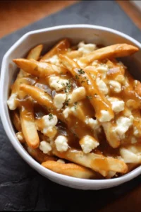 Delicious poutine with fries, cheese curds, and gravy served in a rustic bowl