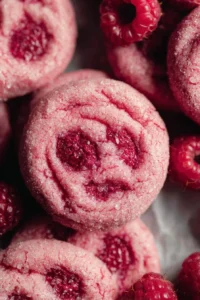 A plate of freshly baked raspberry sugar cookies with vibrant pink frosting