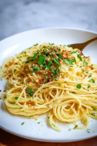 Plate of Spaghetti Aglio e Olio garnished with parsley and chili flakes