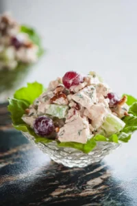 A bowl of Waldorf Chicken Salad featuring chicken, apples, and walnuts