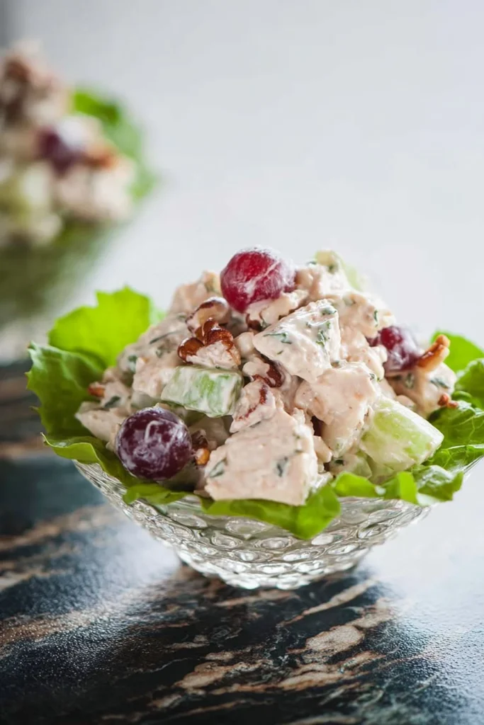 A bowl of Waldorf Chicken Salad featuring chicken, apples, and walnuts