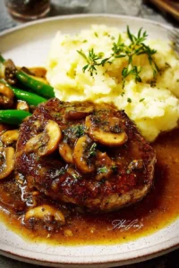 Bobby Flay's Salisbury Steak plated with rich gravy and mashed potatoes