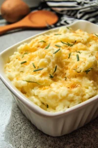 Bowl of cheesy garlic mashed potatoes topped with herbs