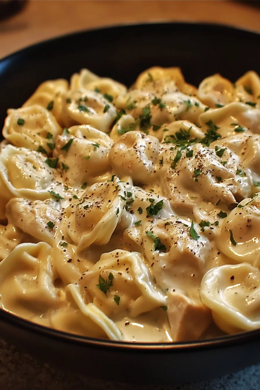Crockpot Chicken Alfredo Tortellini served in a bowl with fresh parsley garnish