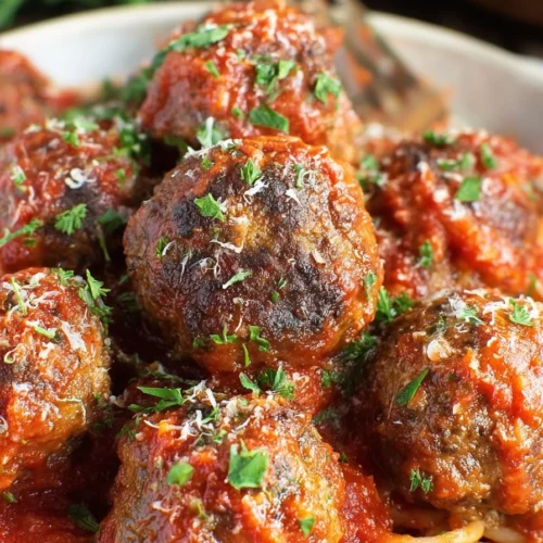Delicious homemade Italian meatballs on a plate with marinara sauce.