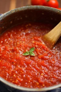 Olive Garden-inspired marinara sauce in a bowl, garnished with herbs.