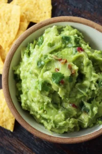 Delicious homemade guacamole served in a colorful bowl with tortilla chips