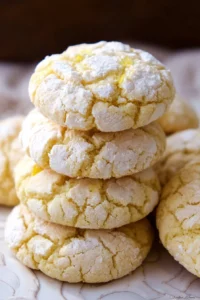 Cream cheese lemon crinkle cookies dusted with powdered sugar on a plate