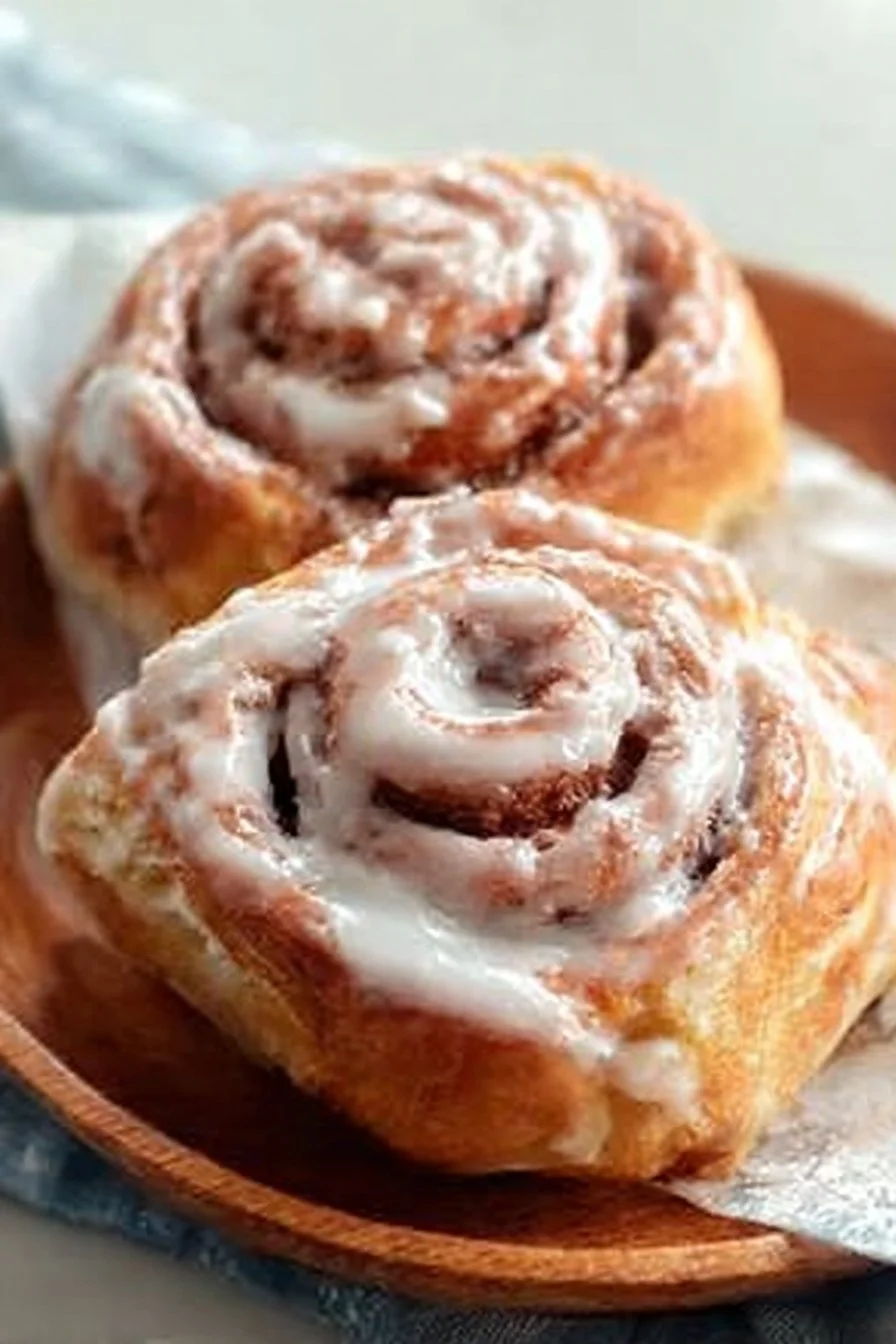 Homemade cinnamon rolls fresh out of the oven topped with icing.