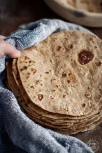 Homemade whole wheat tortillas on a wooden board ready to serve