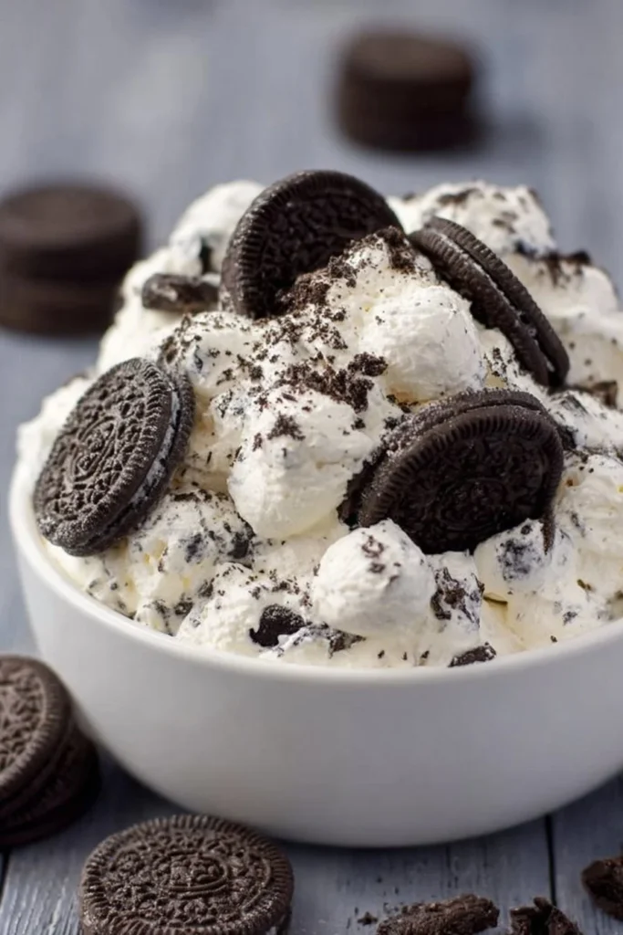 Delicious Oreo Fluff Delight dessert in a glass bowl with crushed Oreos and whipped cream