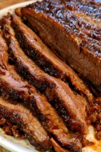 Oven-cooked beef brisket served with sides in a rustic setting