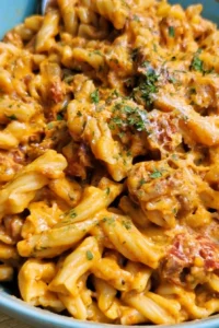 A bowl of cheesy taco pasta garnished with fresh cilantro and cheese