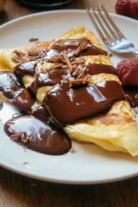 Delicious chocolate ganache crepes drizzled with rich chocolate sauce.