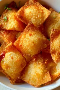 Delicious homemade Crab Rangoon served on a plate with dipping sauce.