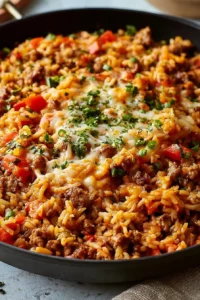 Delicious Ground Sausage and Rice Skillet served in a pan with fresh herbs